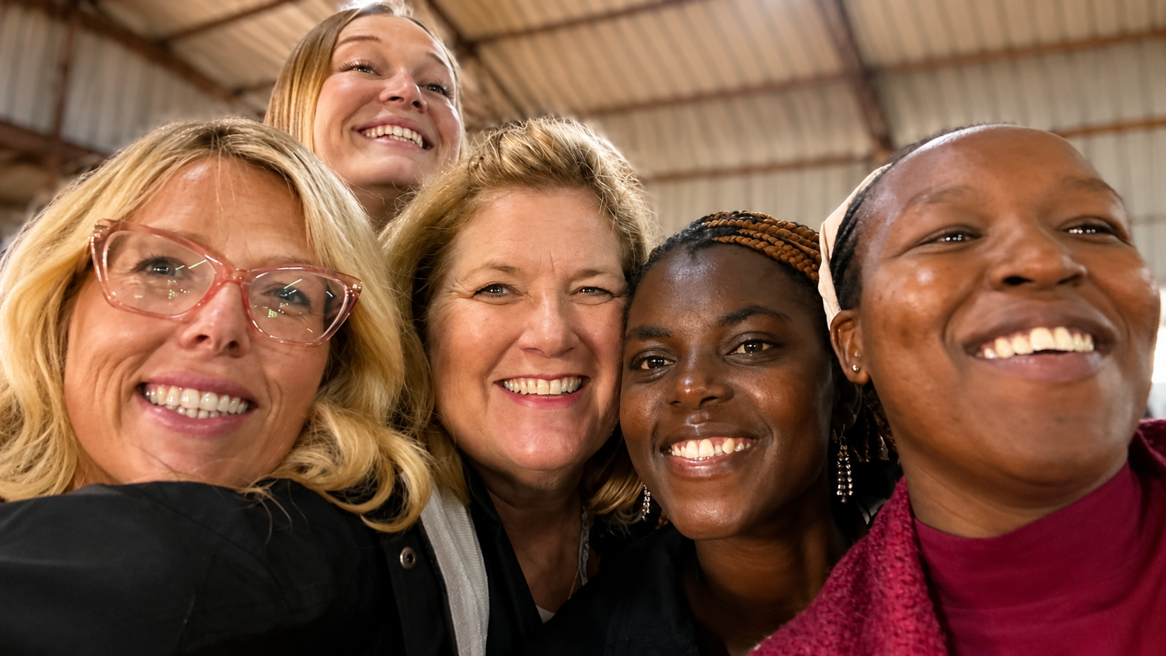 American visitors and Kenyan friends smiling together during a Helping Kenya Kids trip