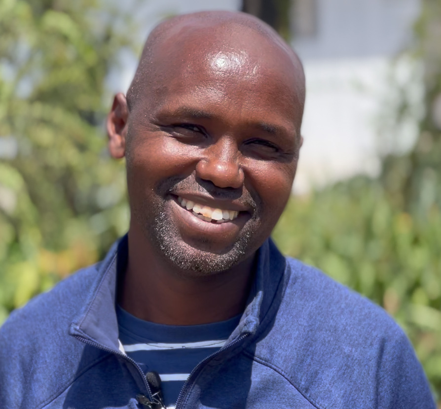 Samson Nangole, National Director of Helping Kenya Kids, smiling outdoors