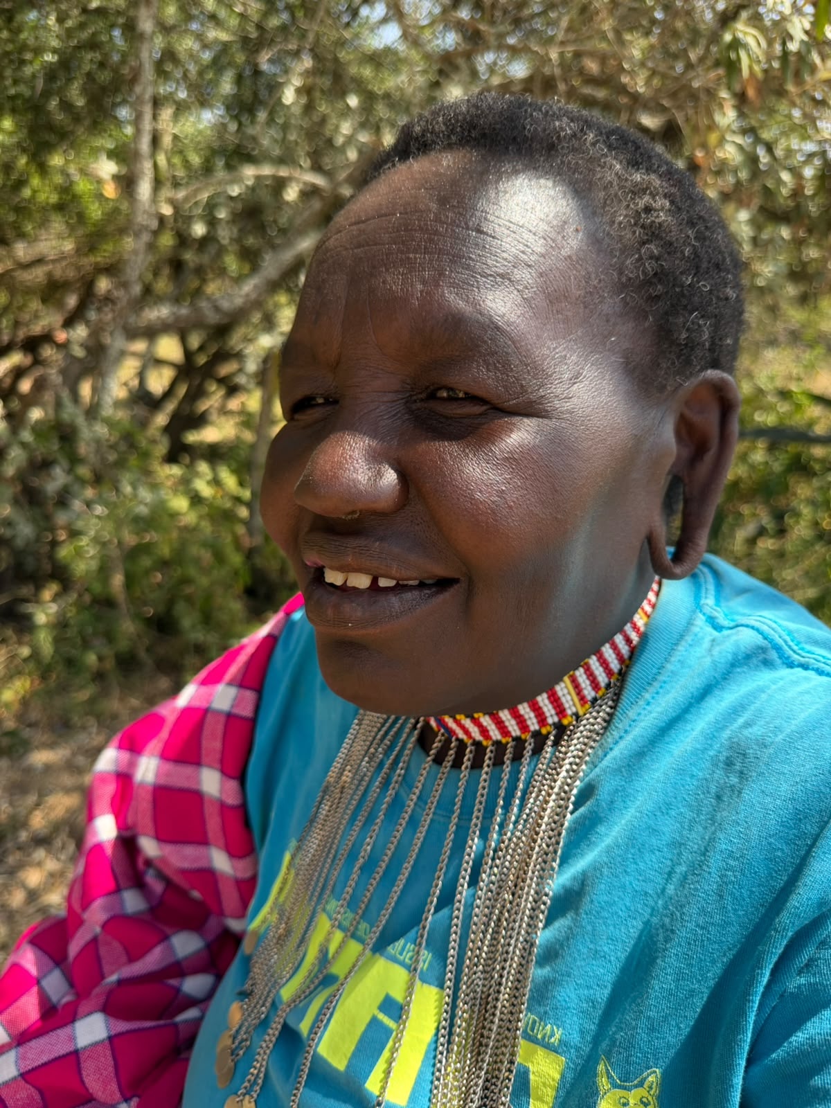 Warm portrait of Esther, a Kenyan woman entrepreneur, smiling in morning light