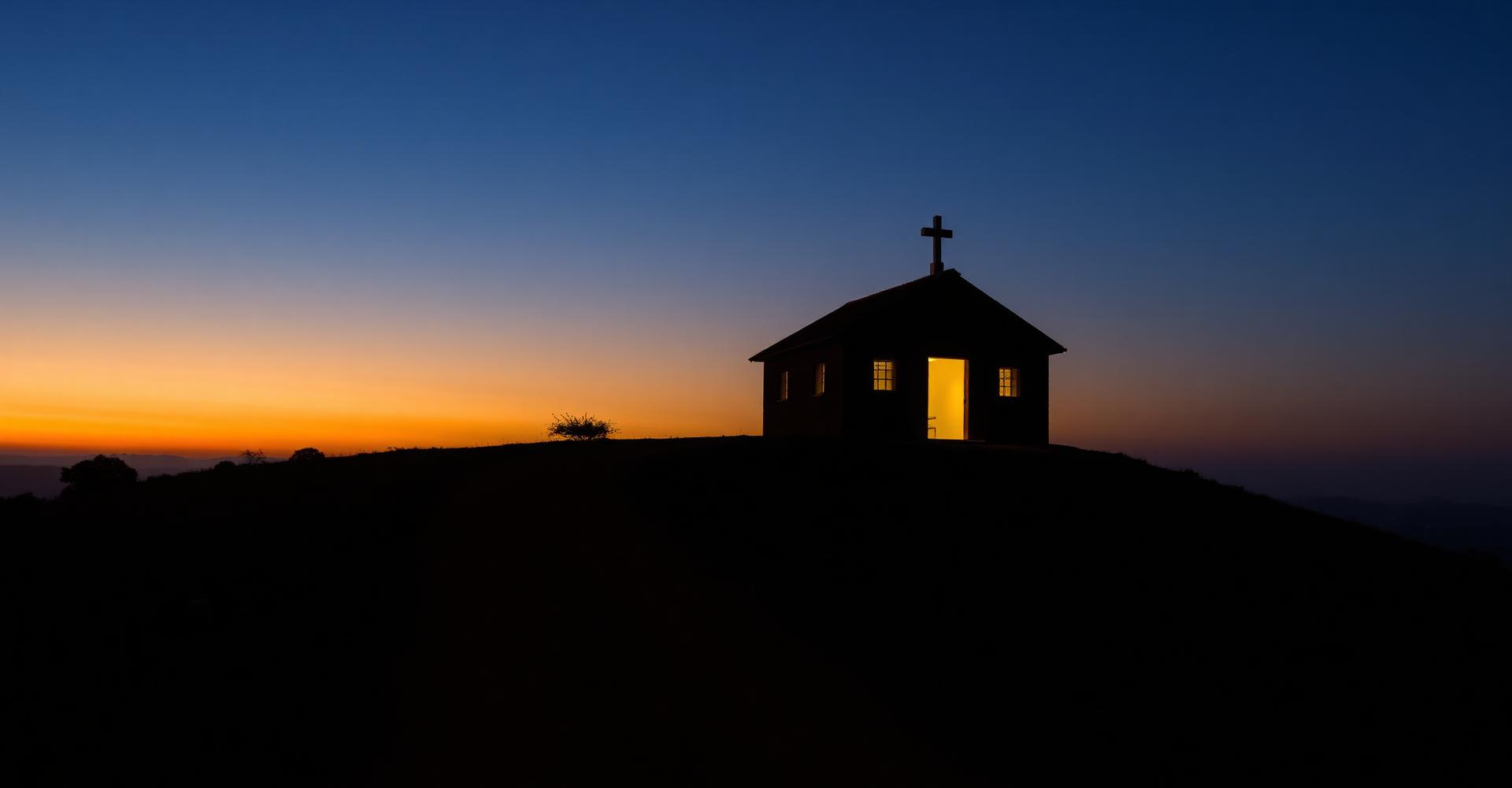 A small chapel glowing at dusk on a rural Kenyan hillside